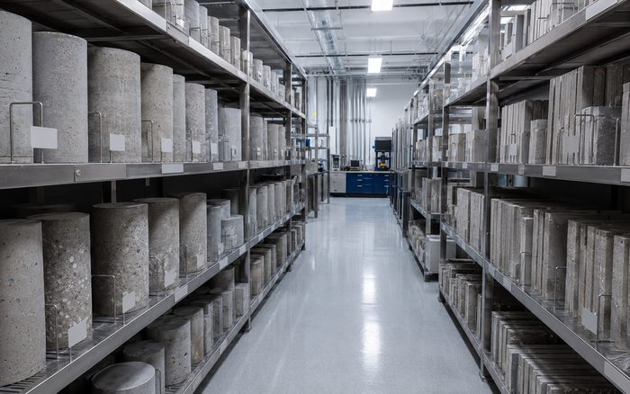 Laboratory storage racks holding labelled concrete cylinders and panel samples