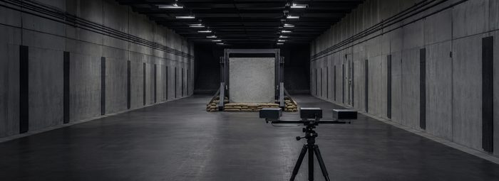 Indoor ballistic test range with a concrete panel mounted downrange